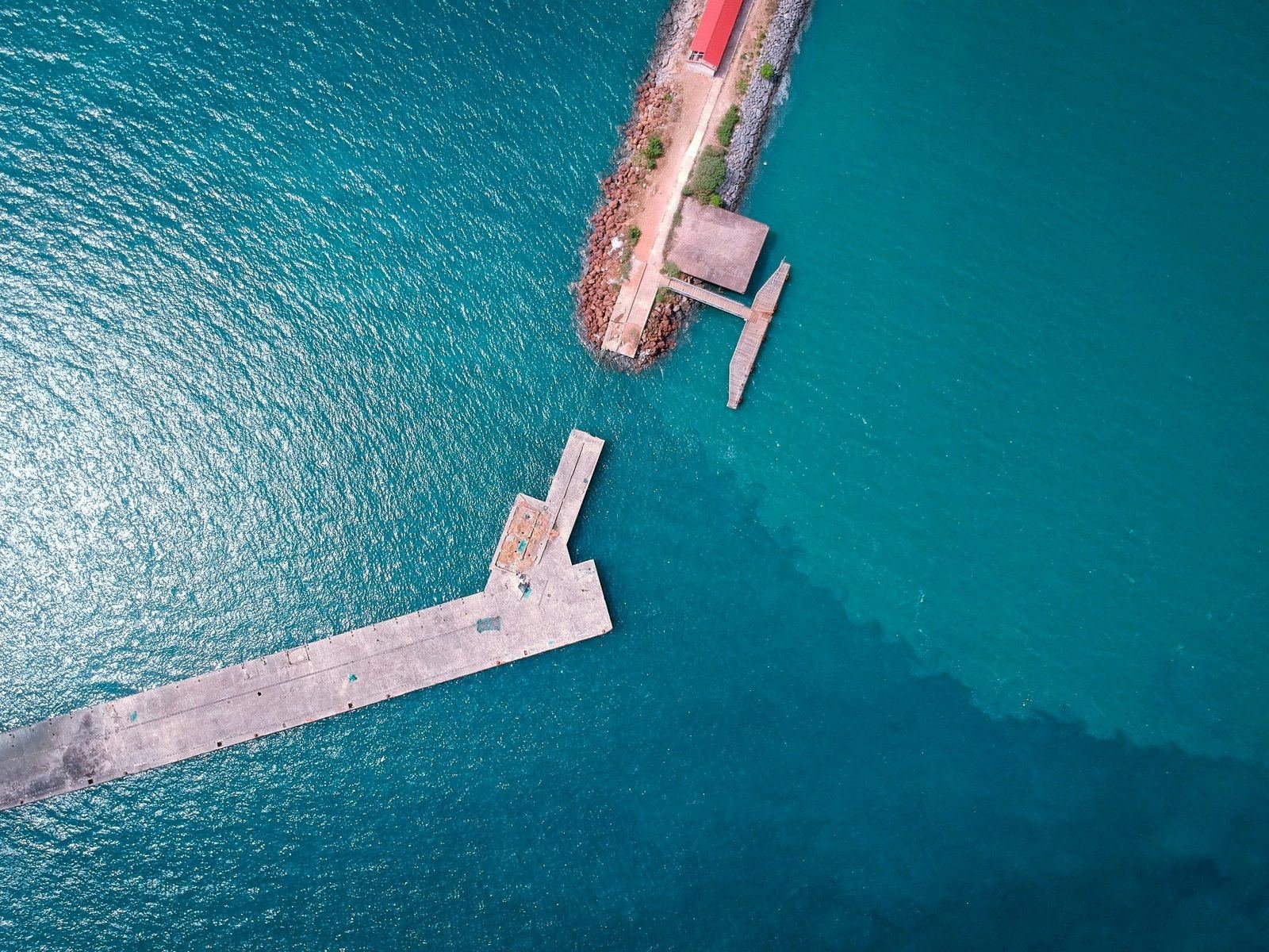 Aerial view of a jetty over turquoise water.